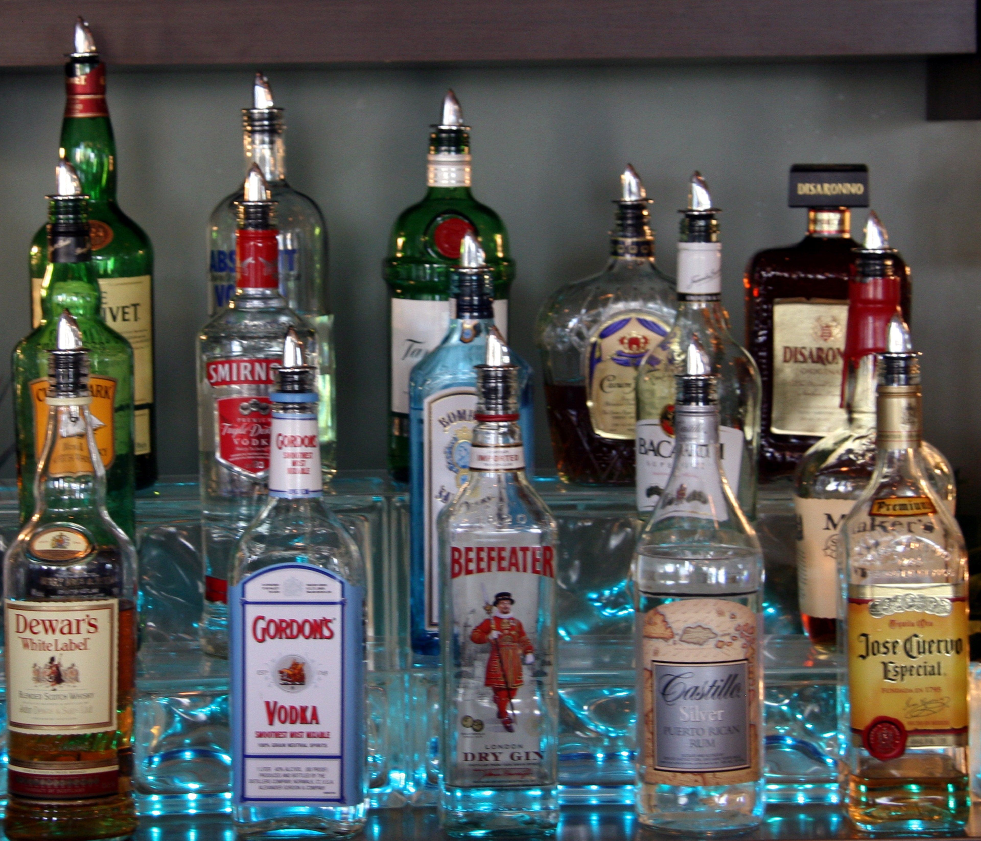 A variety of liquor bottles on a shelf.