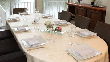 Une table à manger dressée pour six personnes, avec vue sur une rivière et un pont.