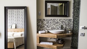A modern bathroom with a large mirror, a vessel sink, and a wooden vanity. - Serendipity Rooms (Milan)