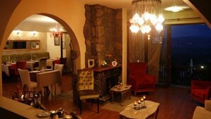A cozy interior with a stone fireplace, comfortable seating, and a balcony with a night view. - Villa Pine Garden (Sile)
