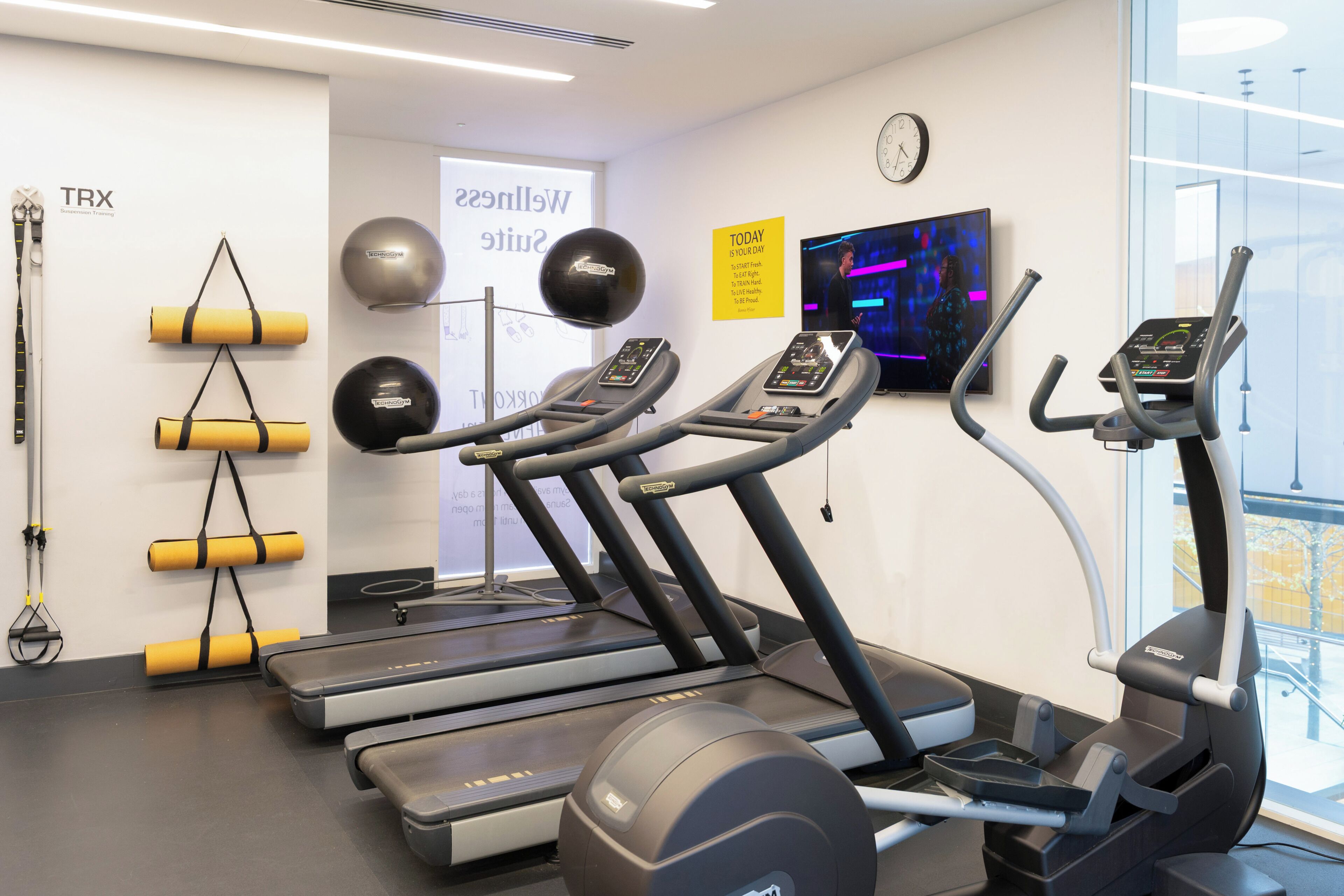 Ein Fitnessstudio mit Laufbändern, Übungsbällen und Widerstandsbändern.