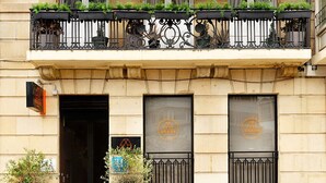 A hotel with a balcony, potted plants, and a sign indicating it is the Okaya Hotel. - Okako Hotel (San Sebastián)
