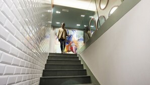 A staircase with a modern design, featuring a glass railing and a patterned wall on one side. - Okako Hotel (San Sebastián)