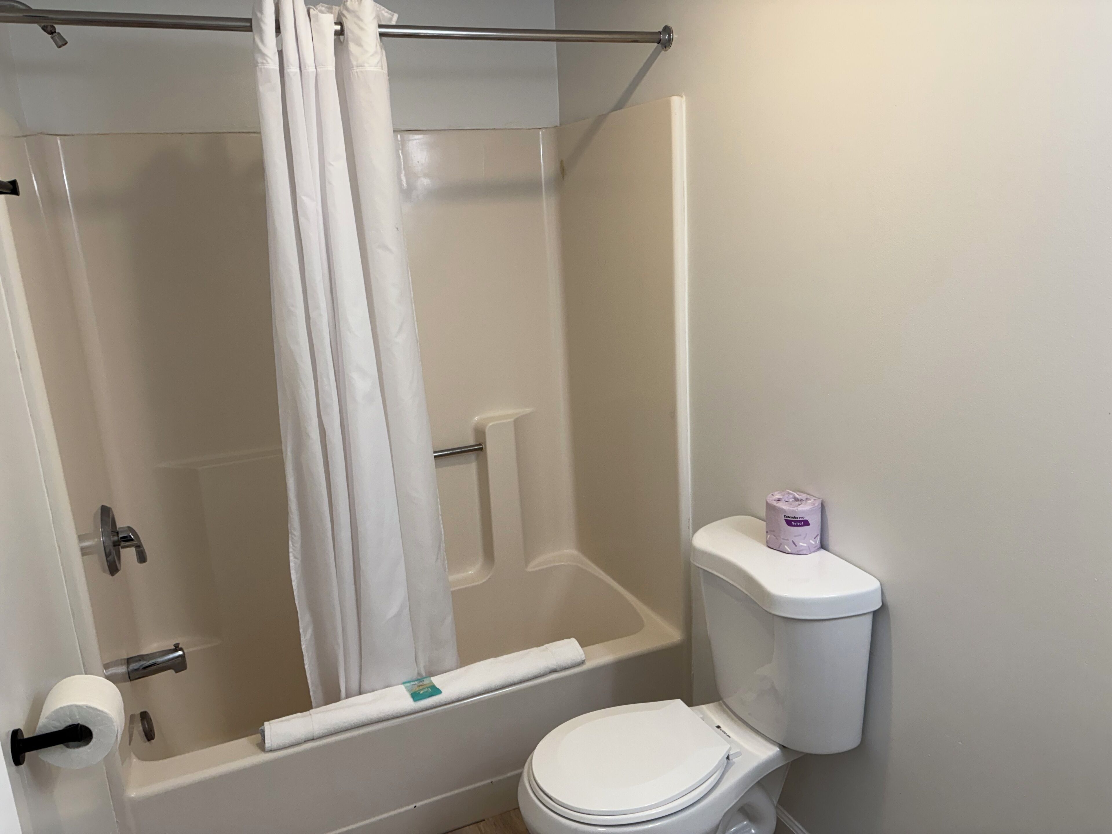 Un baño con bañera, inodoro y cortina de ducha.