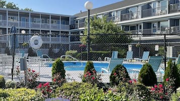 Een buitenzwembad, een verwarmd zwembad, ligstoelen bij het zwembad