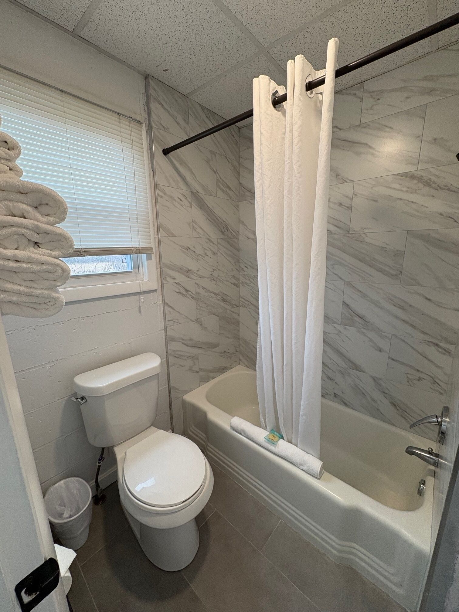 A bathroom with a toilet, bathtub, and shower curtain.
