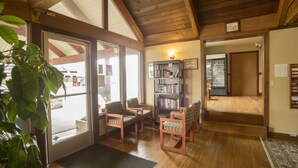 A cozy room with wooden floors, a bookshelf, and a door leading to a store. - The Forks Motel (Forks)