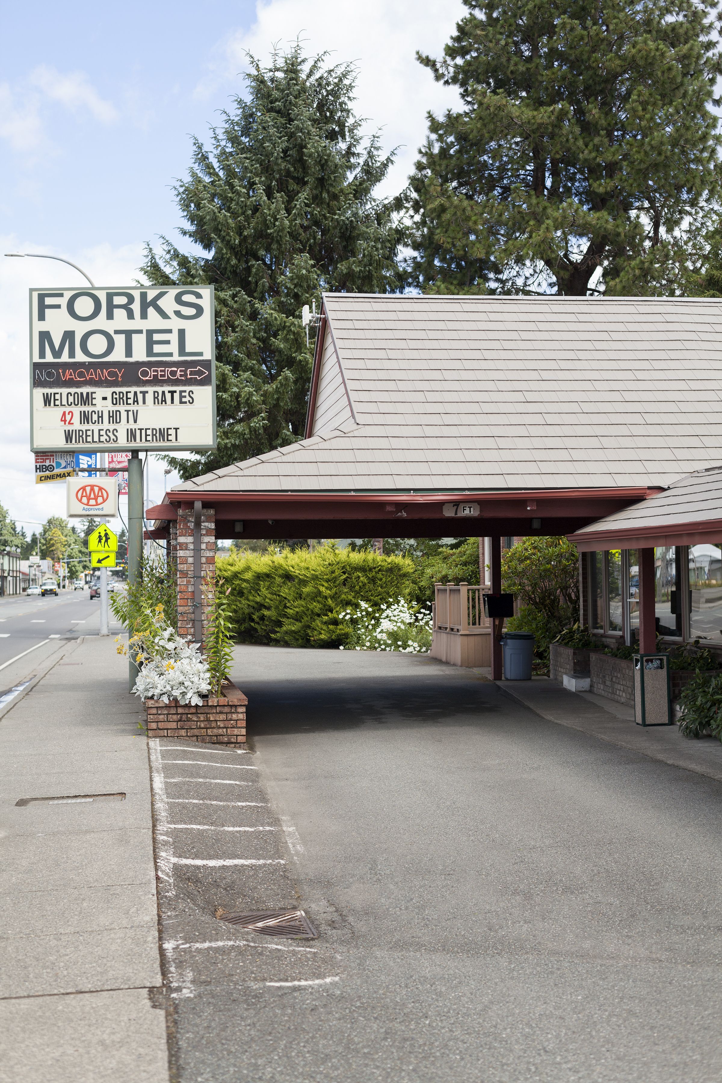 A motel with a sign advertising 42-inch HD TV and wireless internet.