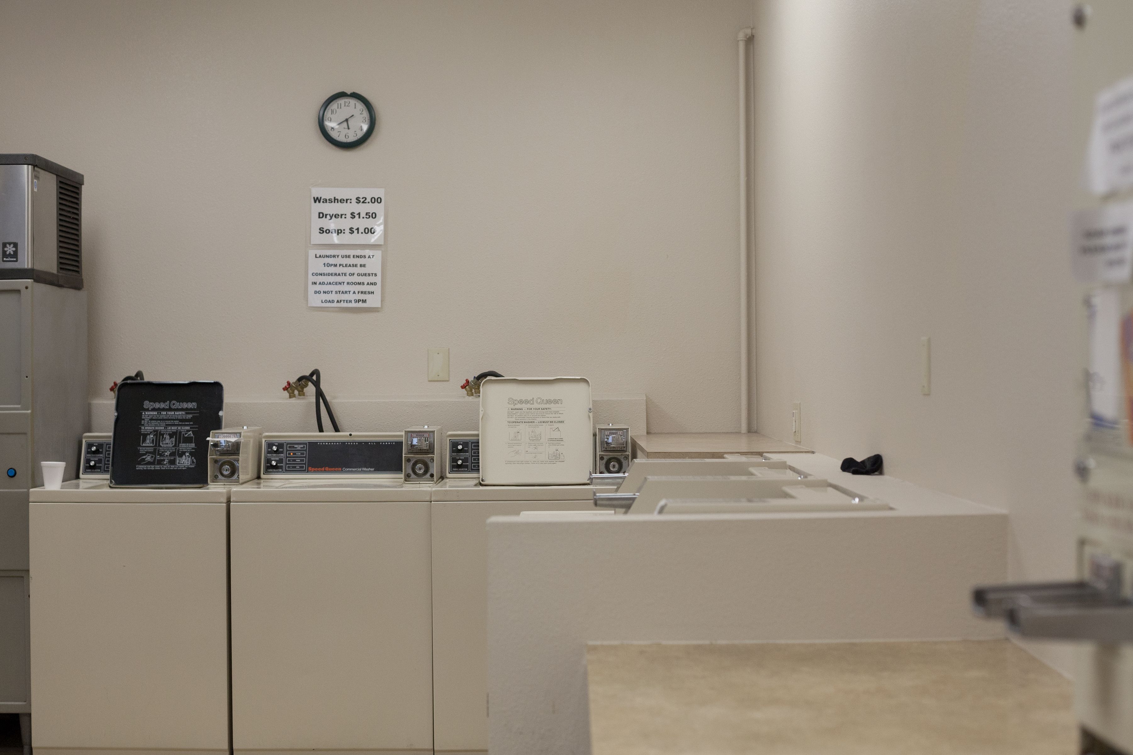 A laundry room with a washing machine, dryer, and Speed Queen label.