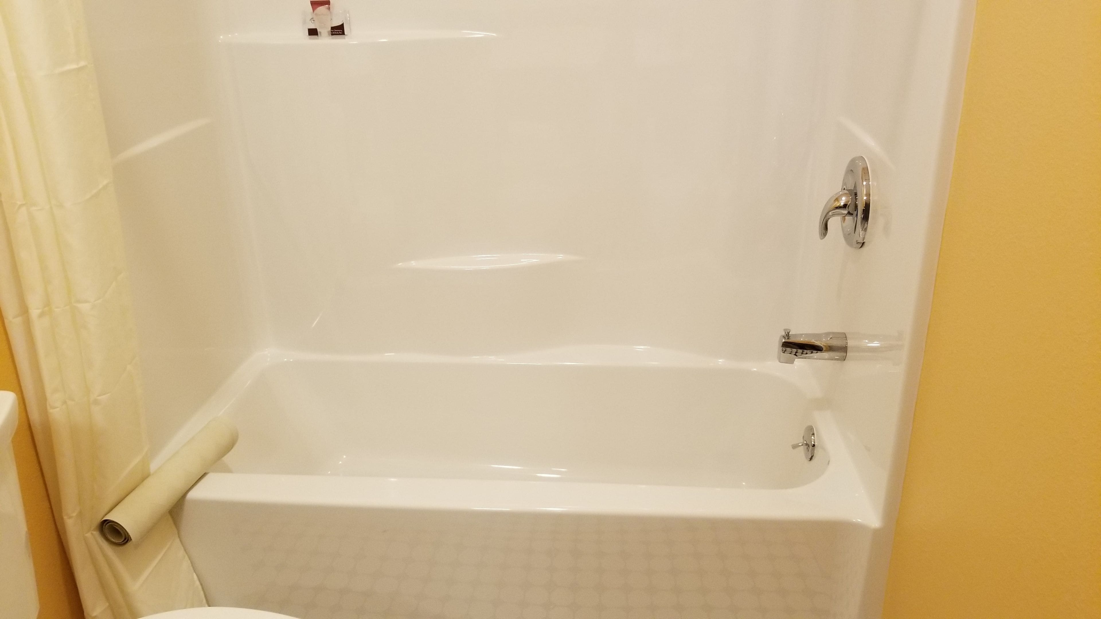 A white bathtub with a chrome faucet and a showerhead.