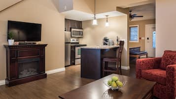 A modern kitchen with a microwave, stove, and dining area with a table and chairs.