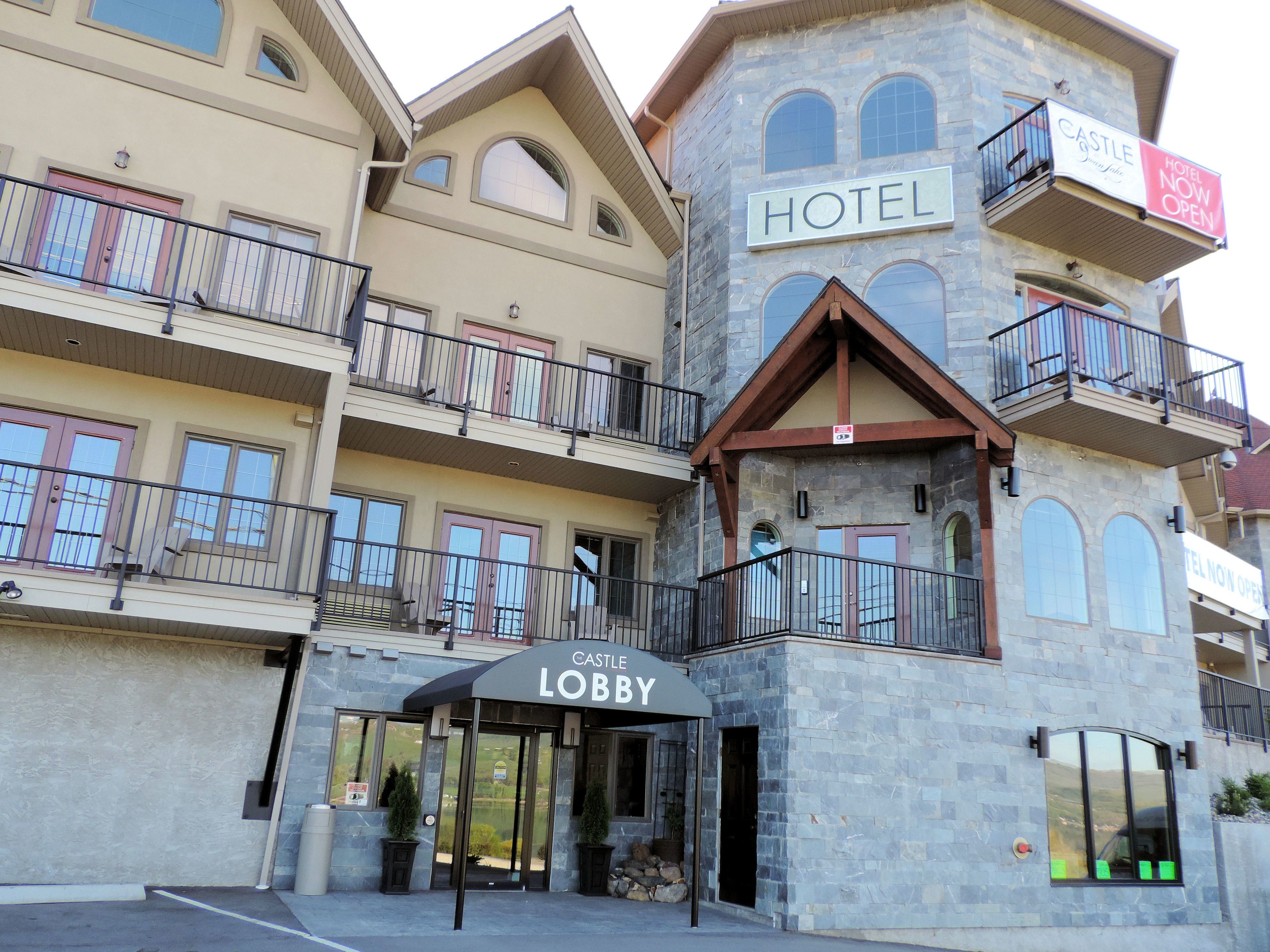 A hotel with a lobby entrance, multiple balconies, and a stone facade.