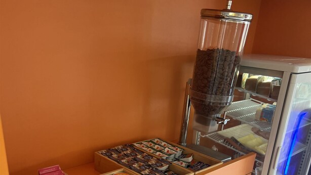 Een ontbijtbuffet met diverse gerechten en een koffieapparaat.