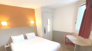 Een hotelkamer met een groot bed, nachtkastjes, een bureau en een stoel.