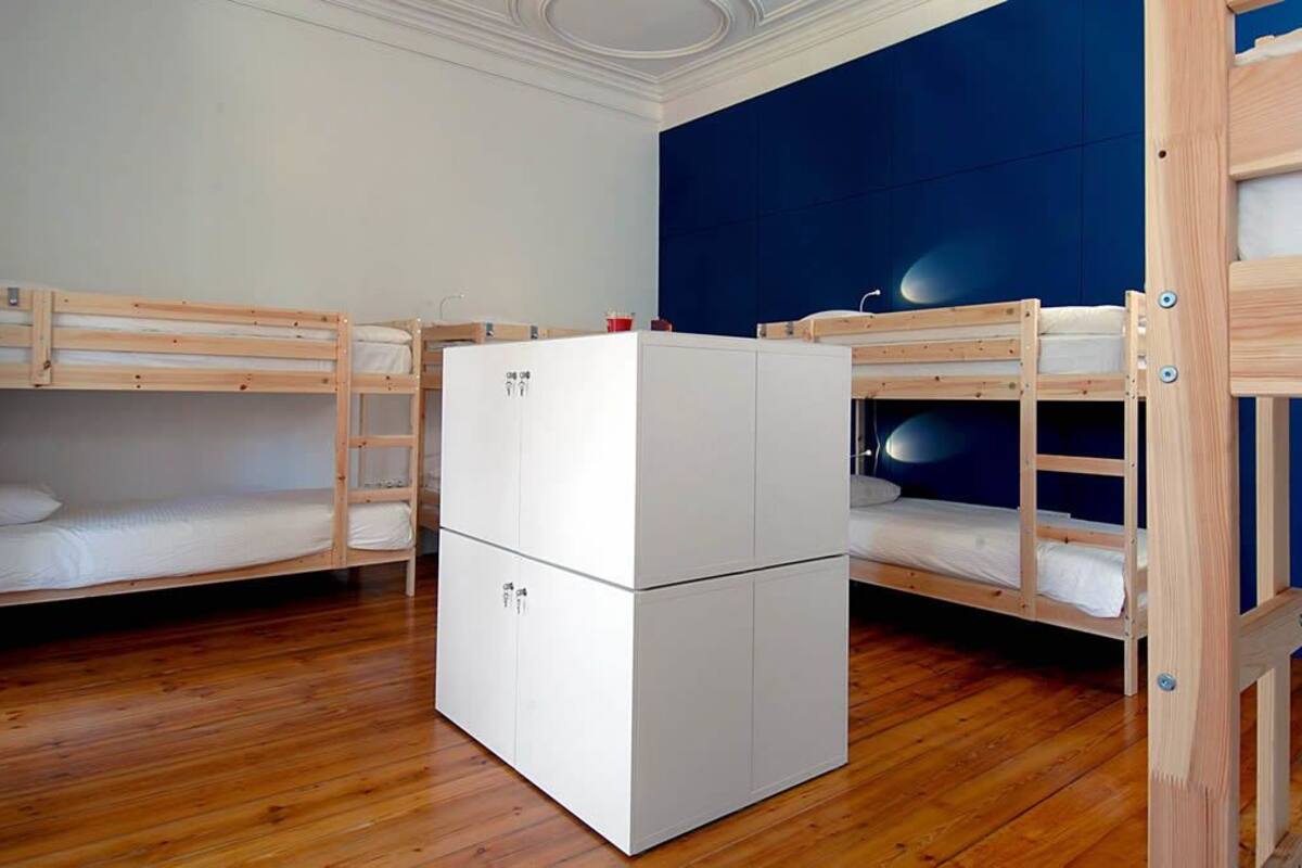 Un dormitorio con literas, un armario blanco y una pared azul de acento.