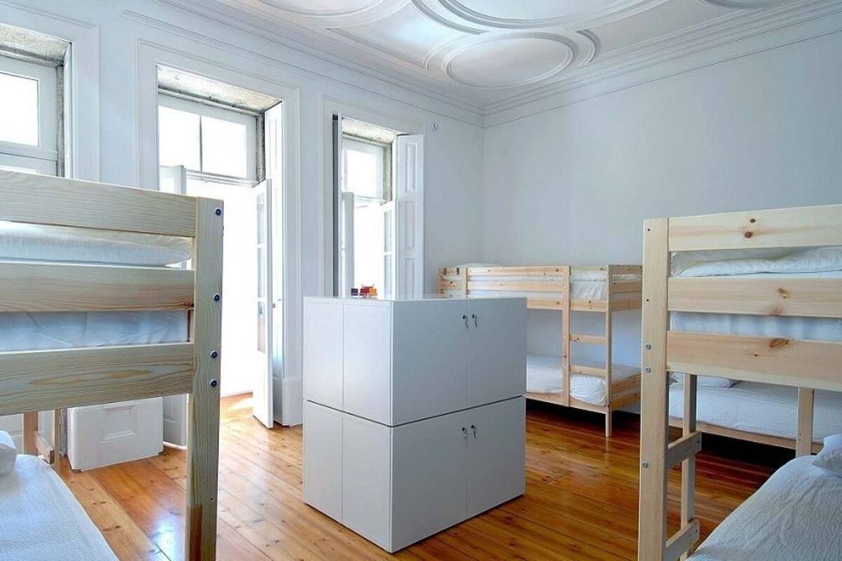 Una habitación con literas, un armario blanco y una ventana.
