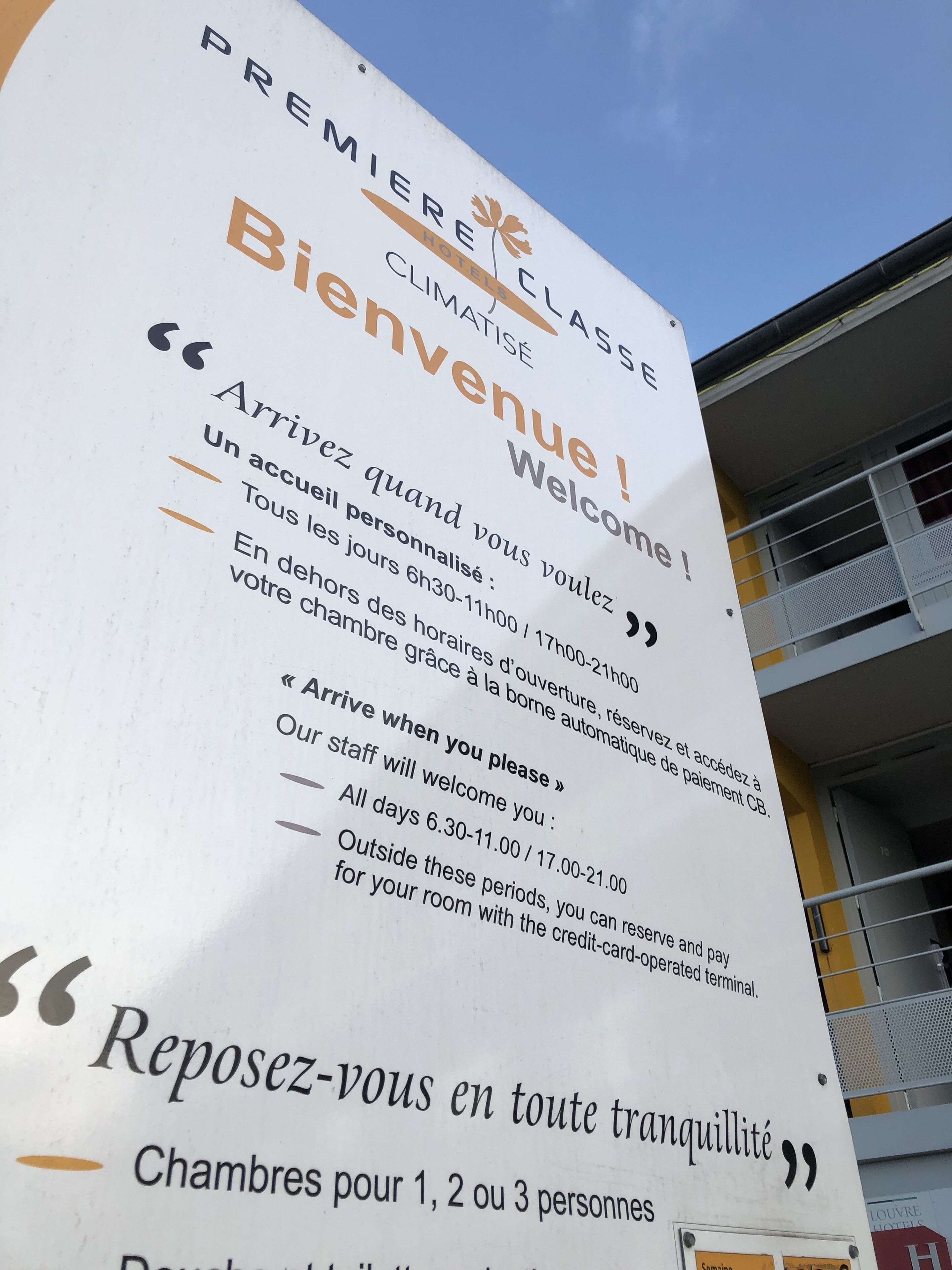 Een hotelsbord met welkomstberichten en openingstijden.