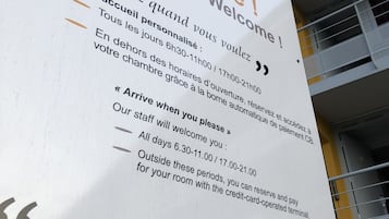 Een hotelsbord met welkomstberichten en openingstijden.