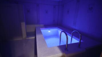Bathroom features a rectangular bathtub and tiled floor and walls.
