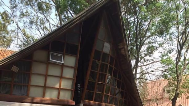 A traditional wooden pavilion with a sloped roof, surrounded by a wooden deck and benches. - Chalé Hotel (Bauru)