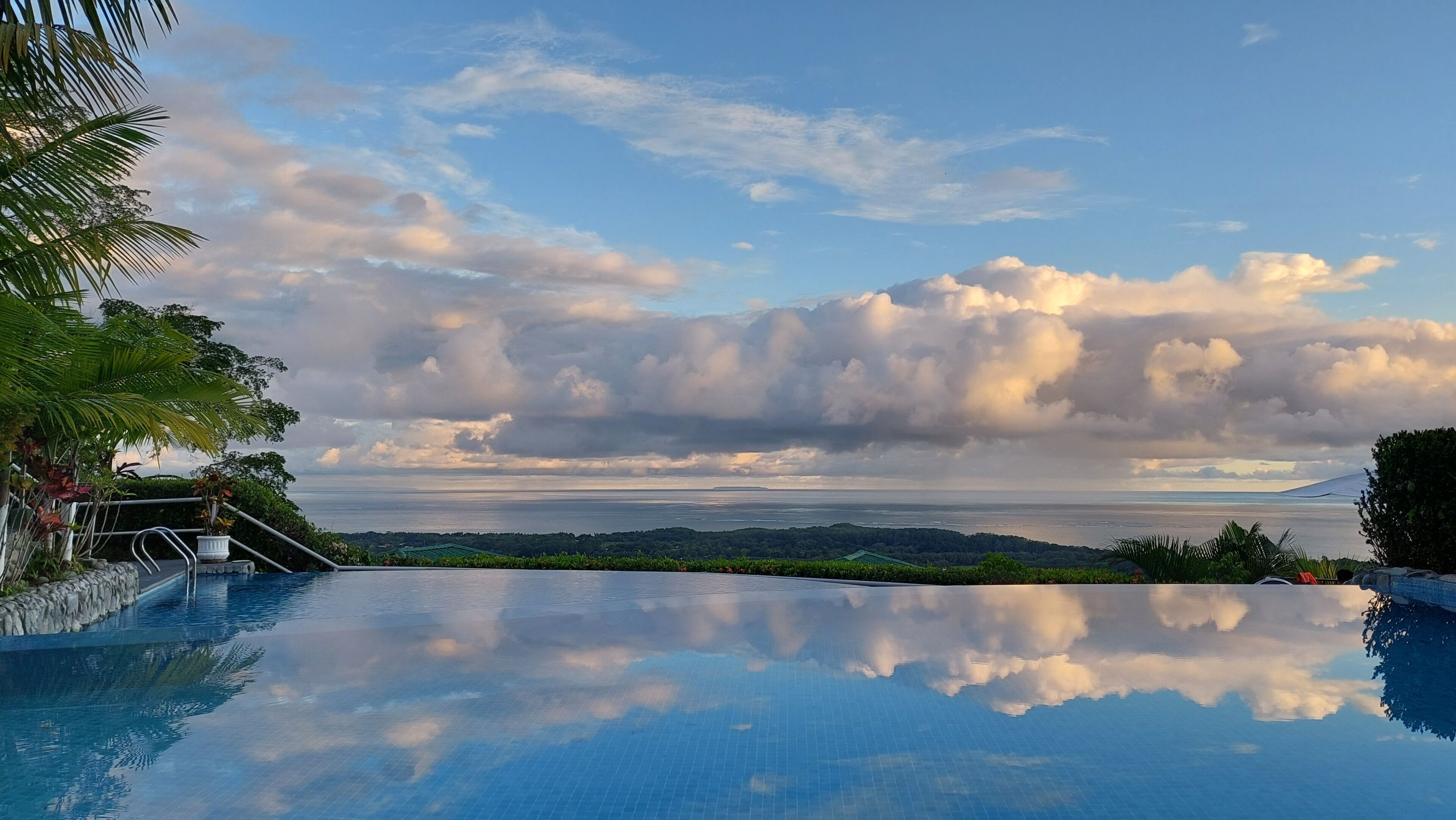 Una piscina con vista al océano y nubes.