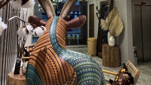 A lobby with a decorative sculpture of a rabbit, a chandelier, and a clock on the wall. - Zen Suites by Regente (Oaxaca)