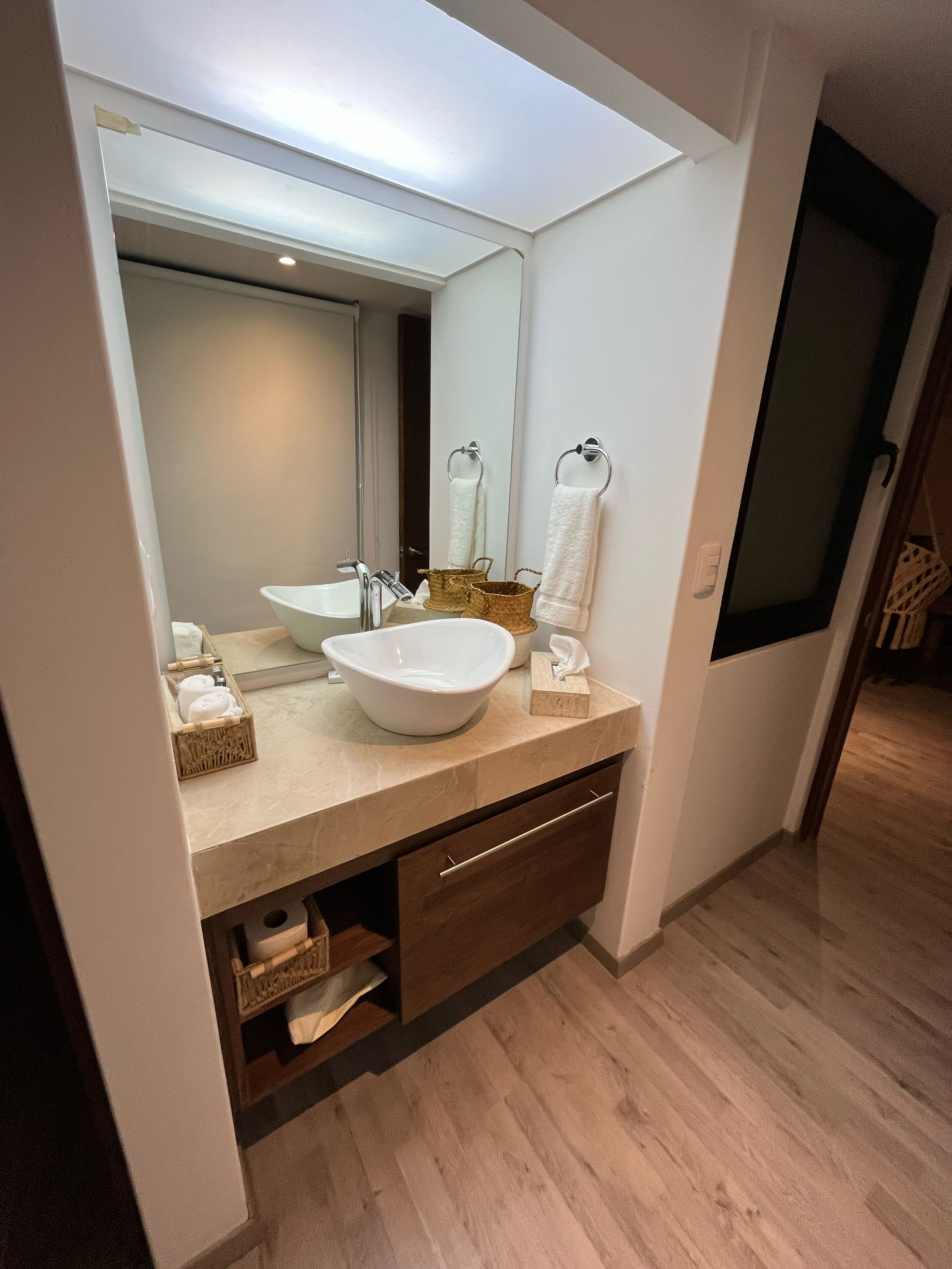 Une salle de bain moderne avec un grand miroir, deux lavabos et un meuble-lavabo en bois.