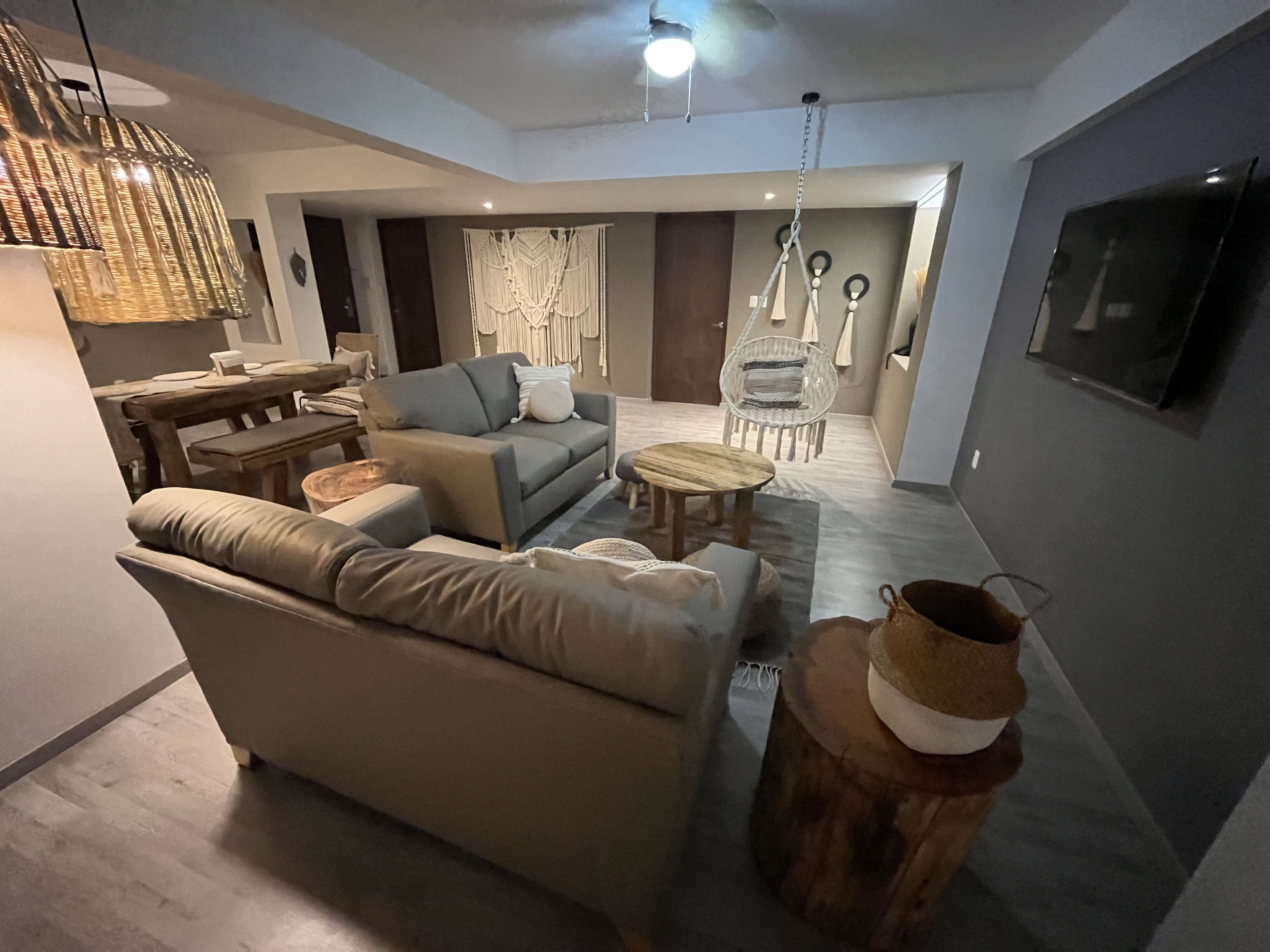 A modern living room with a sofa, coffee table, and hanging chair.