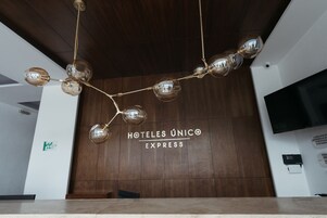 Zona de recepción con pared de madera y un letrero que dice "HOTELES ÚNICO EXPRESS".