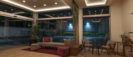 Un vestíbulo moderno con zona de estar, ventanas amplias e iluminación empotrada en el techo.