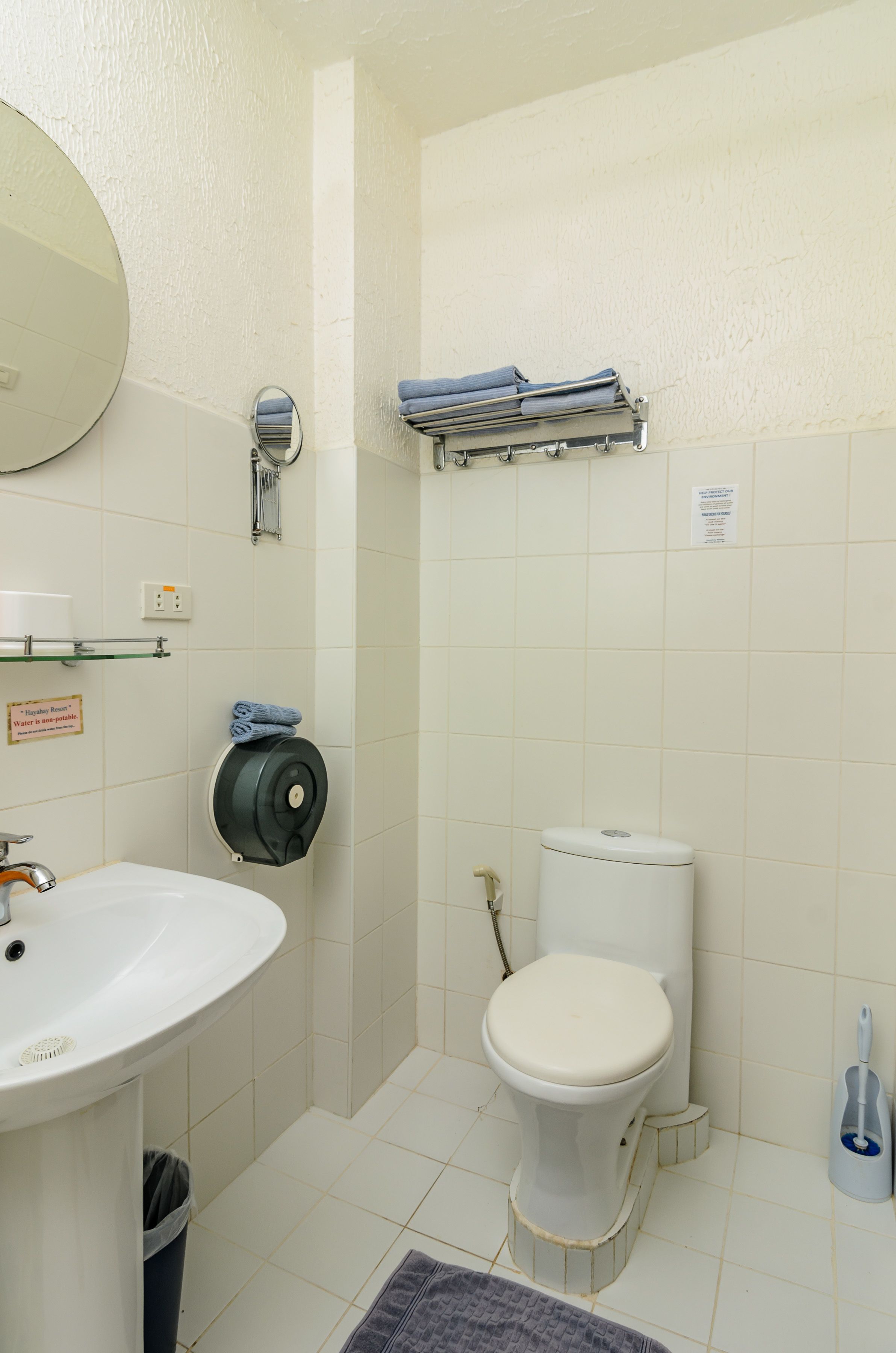 Een kleine badkamer met een wastafel, toilet en een handdoekhouder.