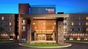 Entrada de um hotel Fairfield Inn & Suites Marriott com design moderno, destacando uma entrada imponente com portas de vidro e uma cobertura.
