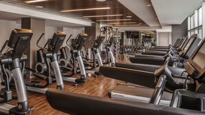 A gym with multiple treadmills, exercise bikes, and weight machines.