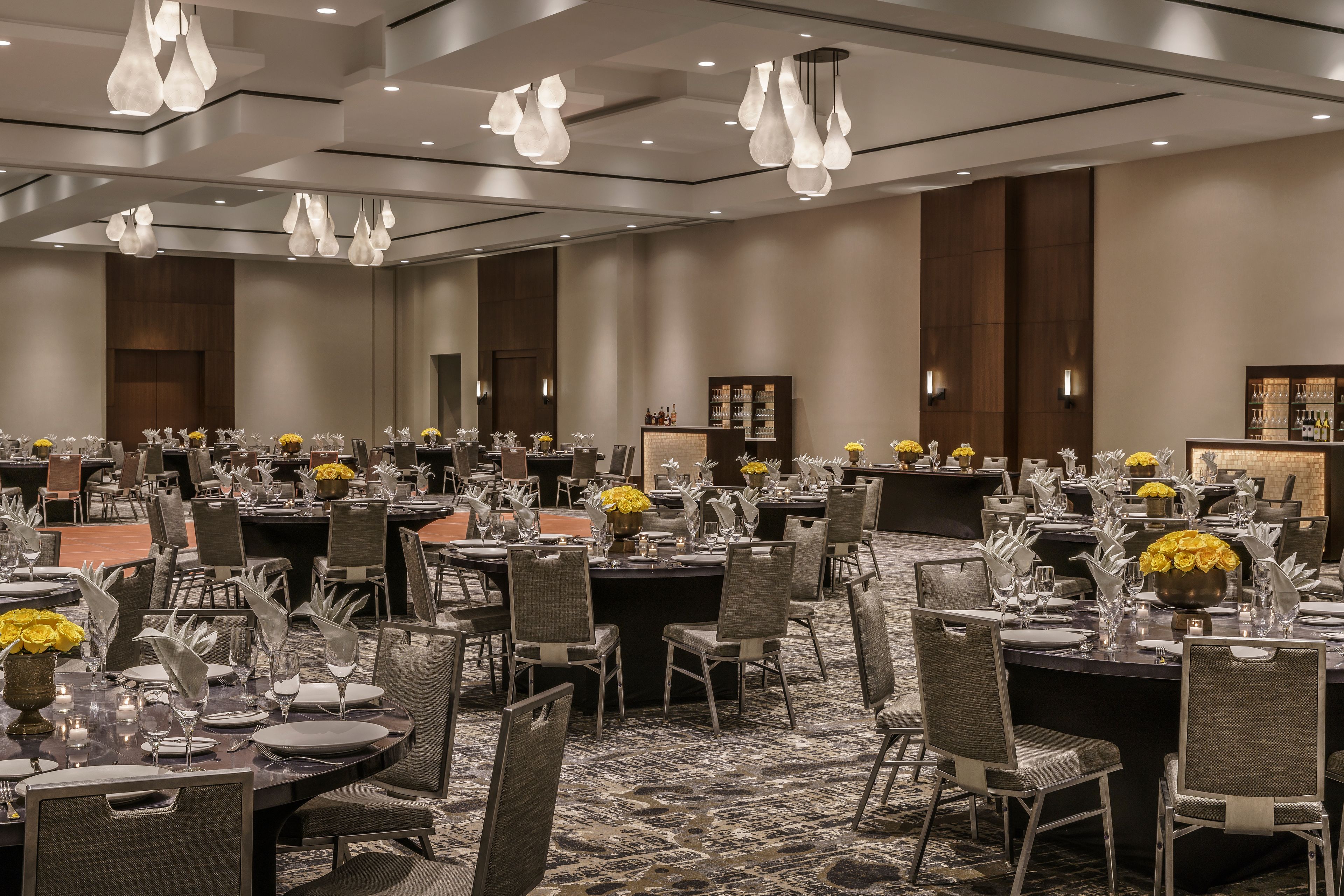 A banquet hall with round tables set for dining, equipped with chairs and table settings.