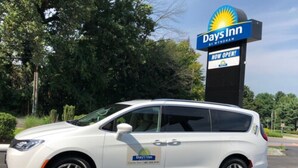 Un coche blanco estacionado frente al cartel de Days Inn.