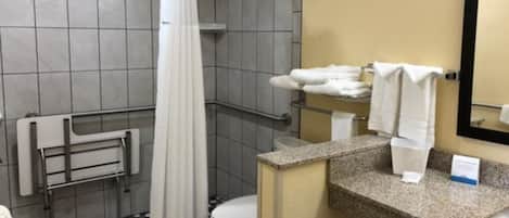 A bathroom with a shower, toilet, and a sink with a towel rack.