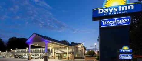 A Days Inn by Wyndham Travelodge with a covered entrance and a parking lot.