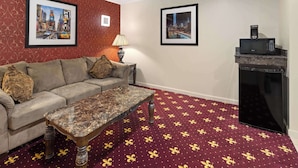 Un salon avec un canapé, une table basse, un tapis à motifs et deux tableaux encadrés accrochés aux murs.