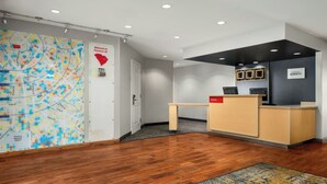 A reception area with a wooden desk, a map on the wall, and a sign welcoming visitors to Florence, SC. - TownePlace Suites by Marriott Florence (Florence)