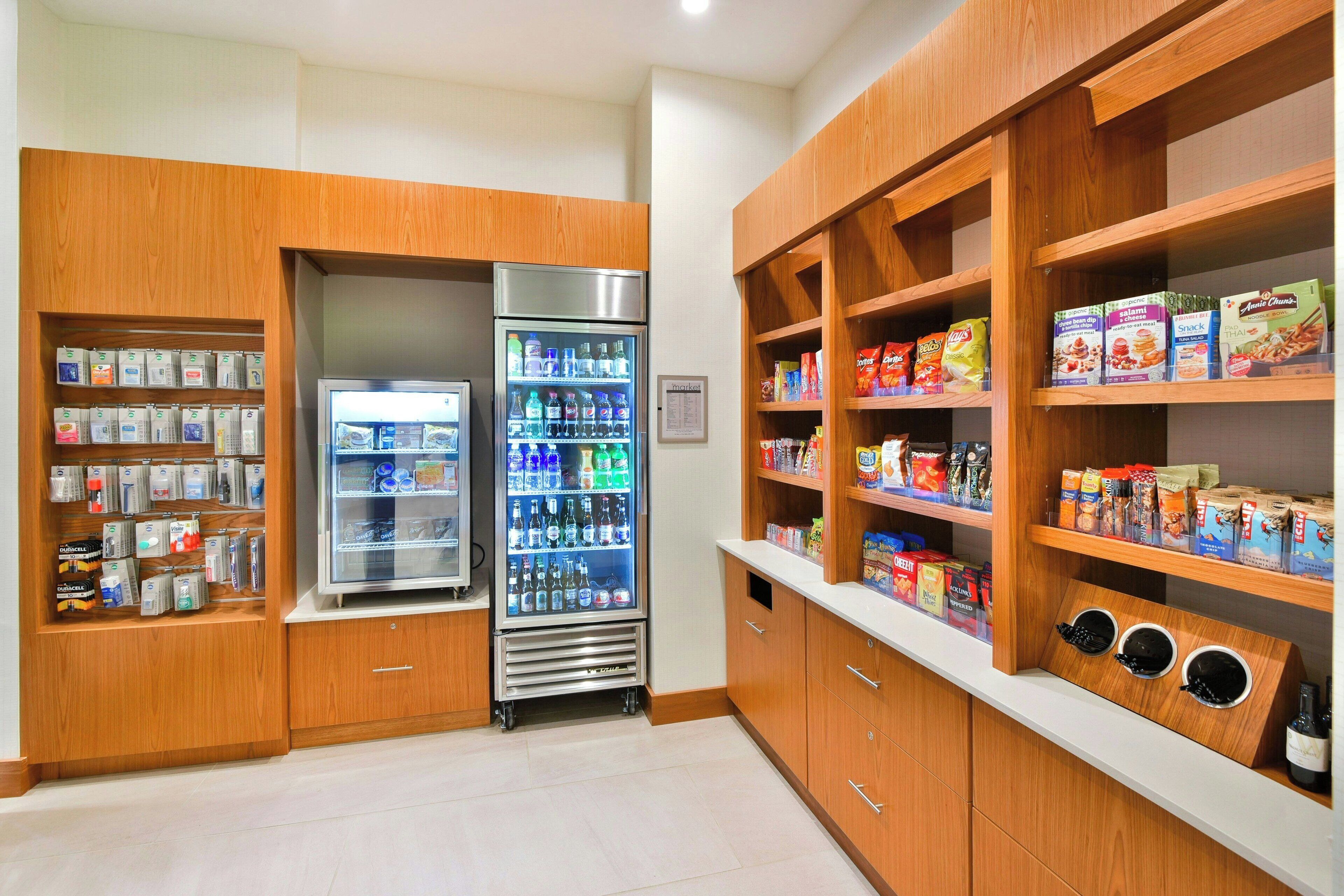 Una kitchenette con armarios de madera, un refrigerador y una estación de café.