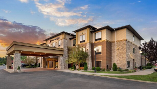 Un hotel con entrada cubierta, varios pisos y fachada de piedra.