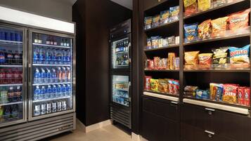 Un área de venta automática con diversas opciones de bocadillos y bebidas, como papas fritas y bebidas embotelladas.