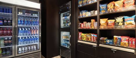 Ett område med försäljningsautomater där man kan köpa olika typer av snacks och drycker, inklusive chips och drycker på flaska.