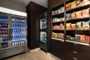 Un área de venta automática con diversas opciones de bocadillos y bebidas, como papas fritas y bebidas embotelladas.