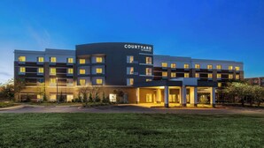 A Courtyard by Marriott hotel with a modern design, multiple floors, and a well-lit entrance. - Courtyard by Marriott Starkville MSU at The Mill (Starkville)