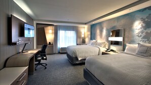 A hotel room with two beds, a desk, a chair, a flat-screen TV, and a large window with curtains. - Courtyard by Marriott Starkville MSU at The Mill (Starkville)