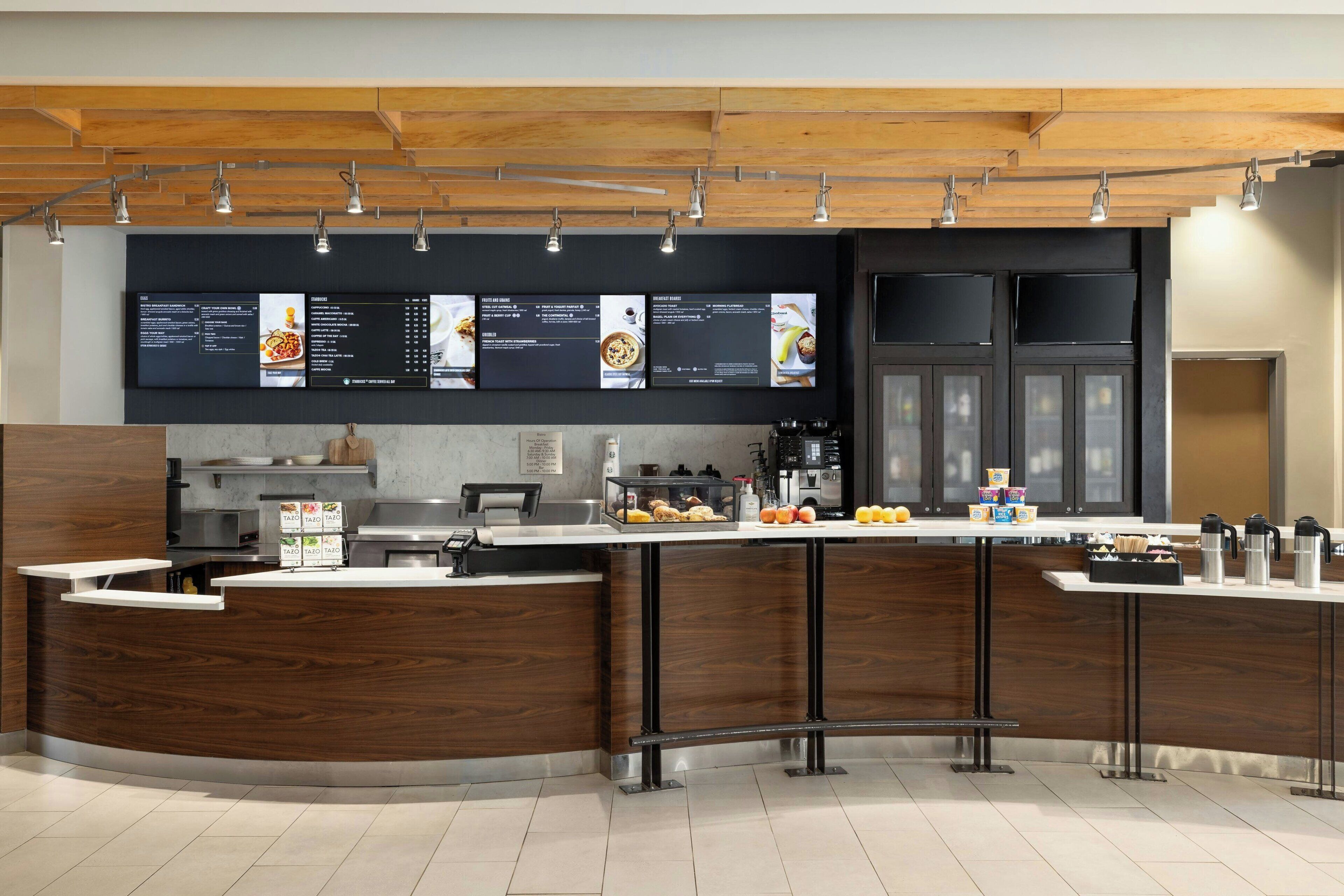 A modern kitchen with a curved island, built-in appliances, and a menu display above the counter.