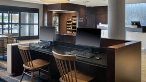 A modern bar area with a computer station, two wooden chairs, a refrigerator, and a shelf with snacks. - Fairfield Inn & Suites Bowling Green (Bowling Green)