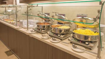 Una mesa de buffet con diferentes alimentos y utensilios para servir.
