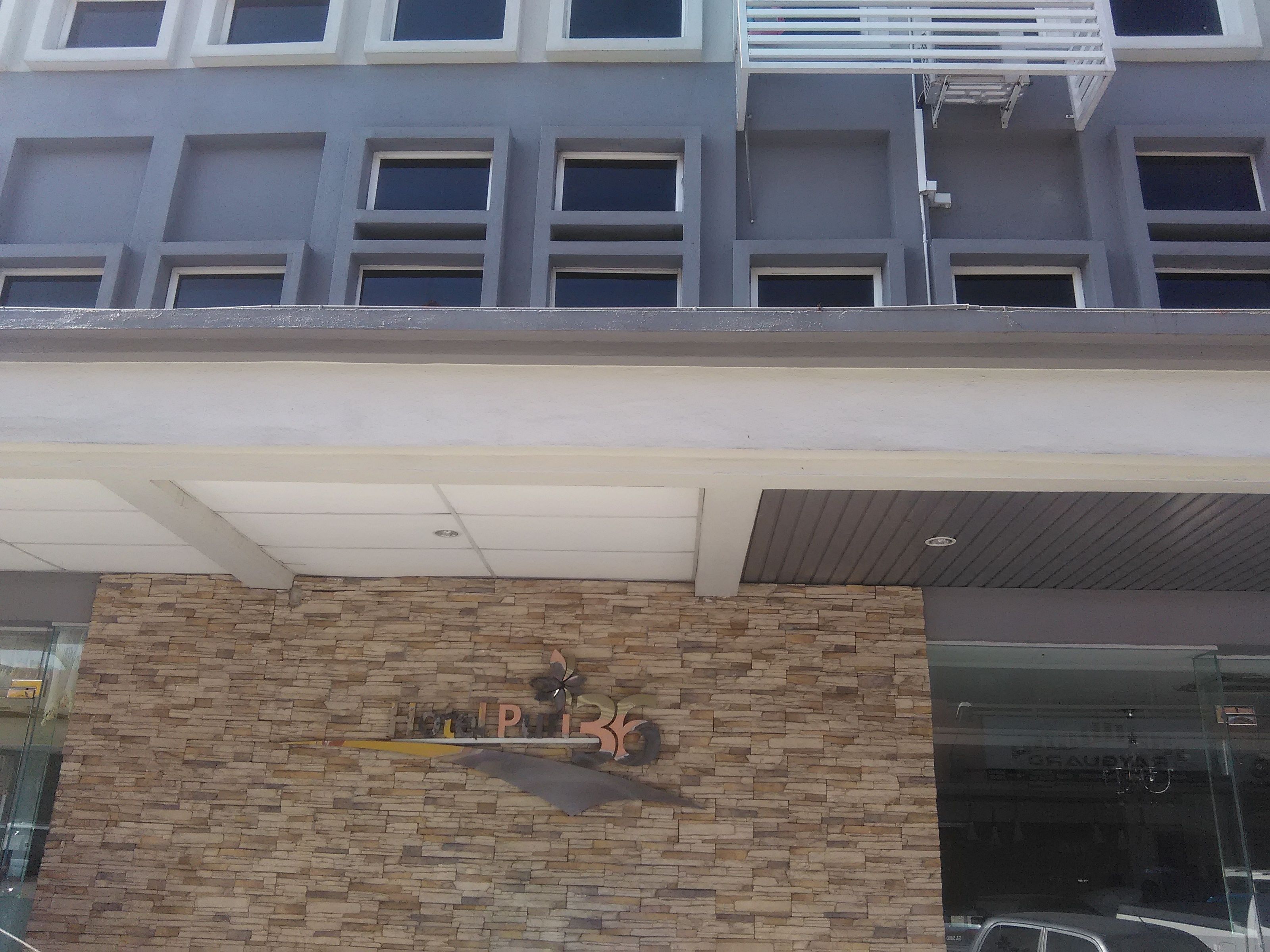 A building facade with a stone wall and a sign that reads "PILOT".